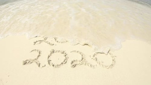 4k video footage of the years 2019 and 2020 written on sand on a beach in Raja Ampat, Indonesia