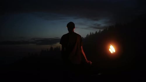 Young Man Performing Fire Twirling in the Night