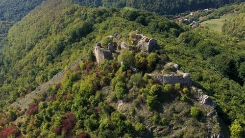 Aerial view of medieval fortress ruins, stronghold on a cliff by drone