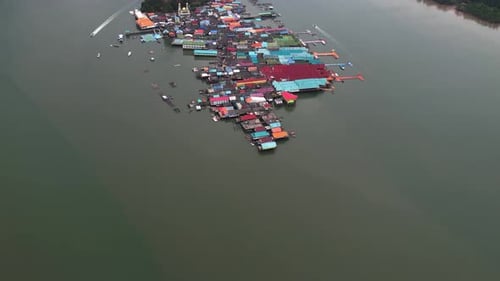 Aerial tilt shot overlooking the Koh Panyee town, in cloudy Phang Nga Bay, Thailand