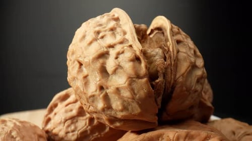 Rotating Close-Up of Walnuts on a Wooden Board