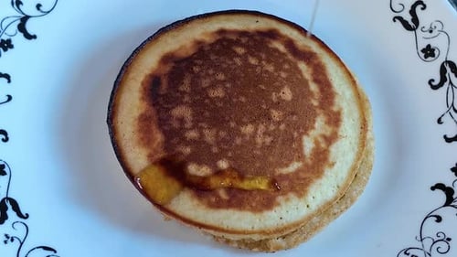 Pancakes Stacked and Covered with Drizzling Honey