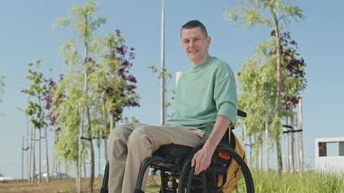 Smiling Young Adult in Wheelchair in Urban Park