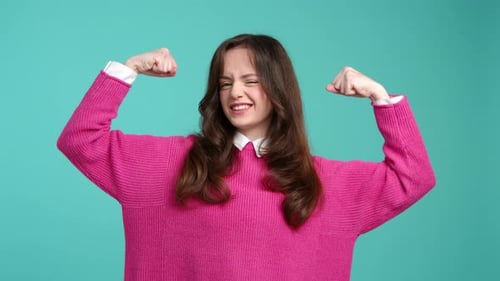 Retrato de uma atraente garota de cabelos morenos mostrando seus músculos