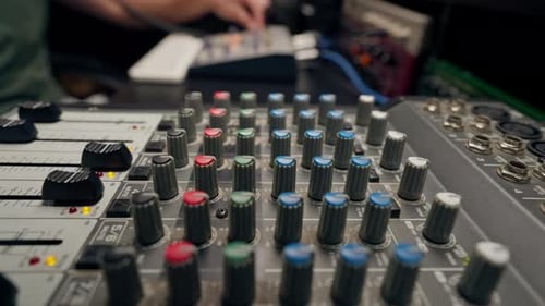 close-up of control buttons of a mixing console for recording soundtrack in a recording studio