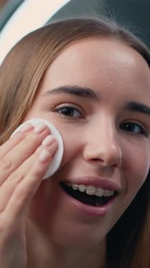Teenage Girl Cleans Her Face with a Cotton Pad