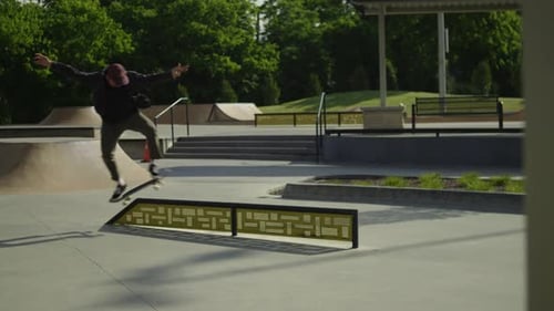 Male skateboarder doing a feeble grind on a rail at a skatepark