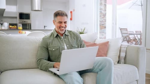 Man Working on Laptop on Couch at Home