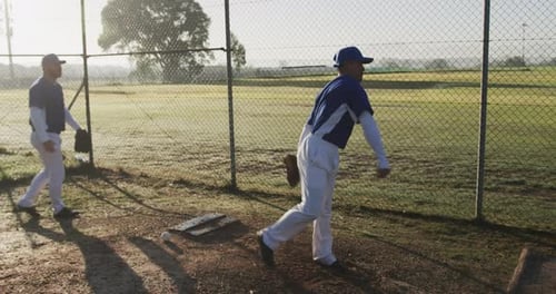 Playing baseball, pitcher preparing to throw ball while teammate watches