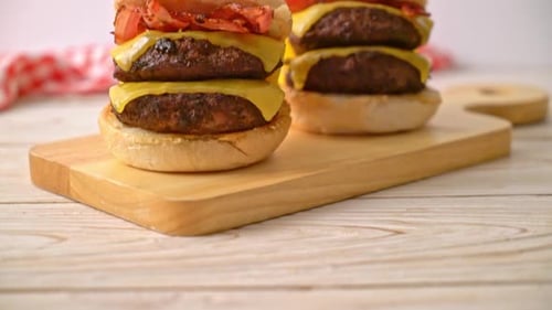 Delicious Double Cheeseburgers with Bacon on Cutting Board