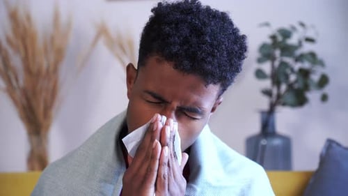 Garçon afro-américain enrhumé et s'essuyant le nez