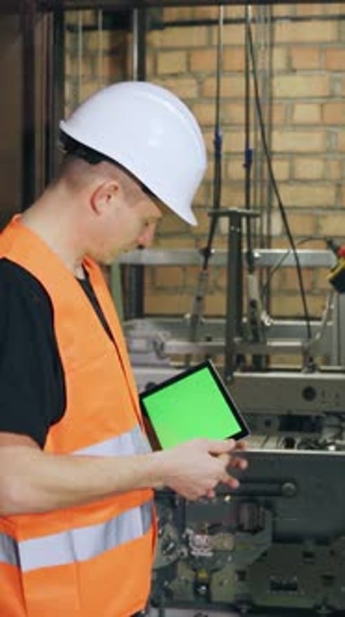 Engineer with Tablet Inspecting Industrial Machinery