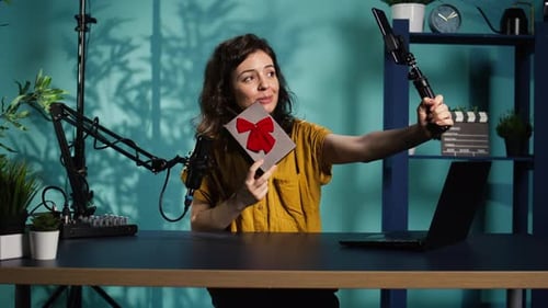 Joyful Content Creator Holding Present Box Filming Giveaway Using Phone
