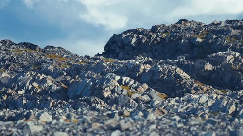 A close-up shot of the rocky formations. Chipped withered rocks covered with moss and lichen. Parall