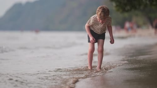 Young Boy Plays on a Sandy Beach