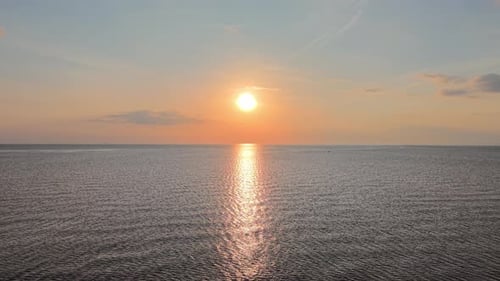 Puesta de sol aérea con un Zumbido sobre el horizonte del océano abierto