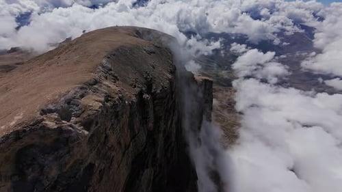 Massive Mountain Peak Rising Above Swirling Clouds Dramatic Sunlight Revealing Pristine Wilderness