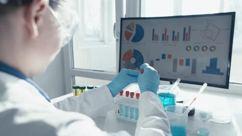 Scientist Analyzing Test Tubes in Bright Laboratory