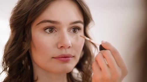 Woman Applies Concealer with Brush, Close Up