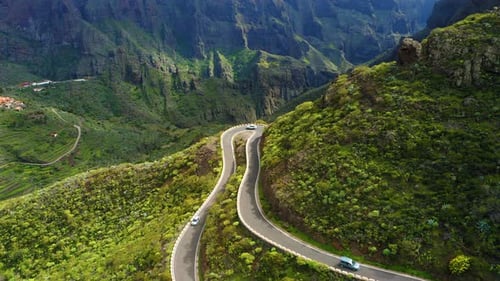 Cars Driving Through Sharp Turn on Winding Zig Zag Serpentine Road in Mountains