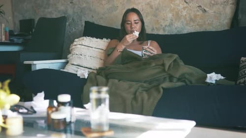 Woman With Cold Blows Nose and Takes Pill