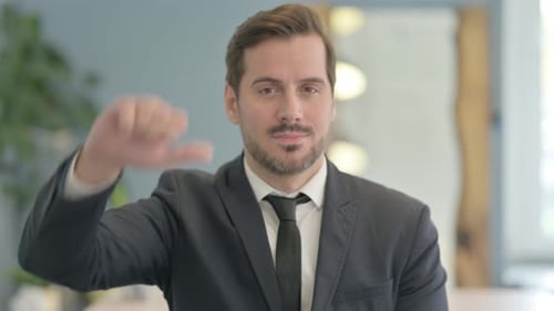 Portrait of Businessman Doing Thumbs Down
