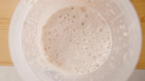 The Camera slowly descends into the cup, revealing the texture and density of the Foam on the