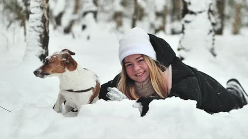 A Girl Playing with Her Jack Russell Terrier Dog in the Snow