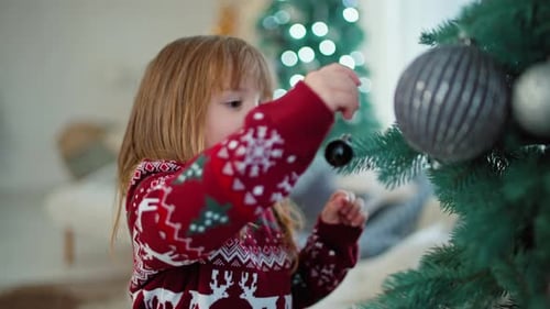 Cute Child Decorating Christmas Tree with Ornaments