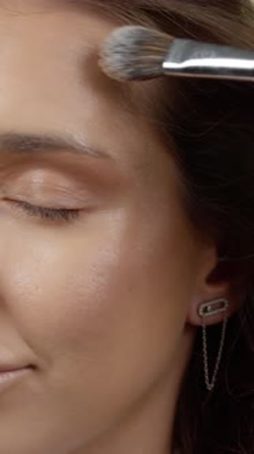 Woman Applying Foundation With Makeup Brush