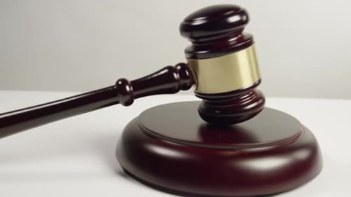 Gavel and Striking Block Close Up on White Surface