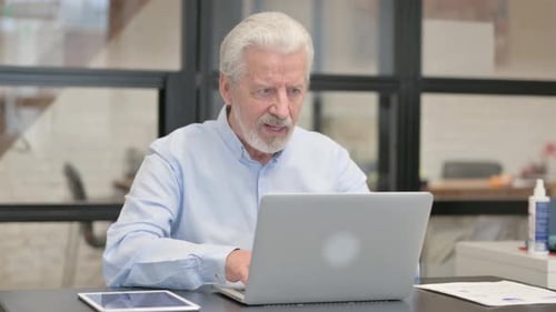 Excited Old Businessman Celebrating Success on Laptop in Office