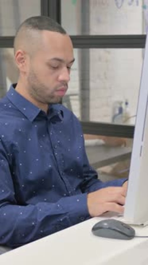 Hispanic Businessman Looking at Camera while Working on Desktop in Office, vertical video
