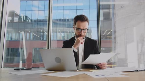 Young Adult Working with Laptop and Business Data