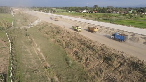 Aerial view of the construction of the highway. Dump truck is passing by the construction.