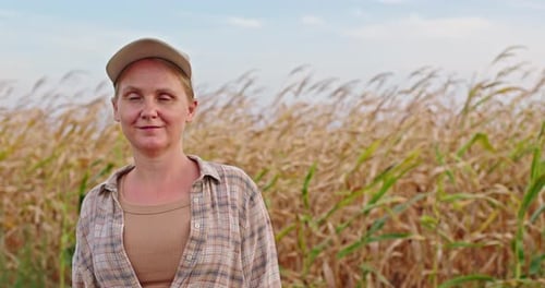 Confident Female Farmer Standing in a Corn Field During Harvest Season Looking Directly at Camera in