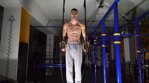 Muscular Shirtless Sportsman Doing Push Ups on Gymnastic Rings at Modern Gym Strong Athlete