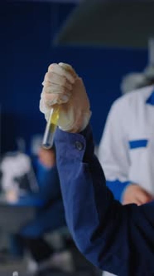 Researcher Holds Test Tube with Liquid in Laboratory