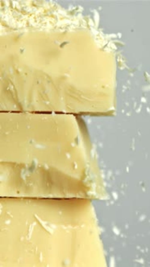 Shredded White Chocolate Falls on a Tower of Chocolate Pieces Filmed on a Highspeed Camera at 1000