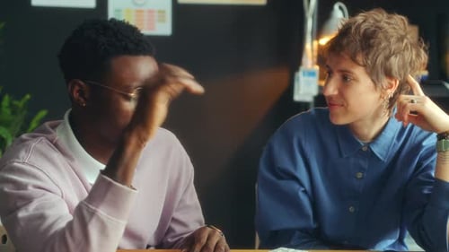 Young Male and Female Colleagues Discussing Ideas during Office Workday