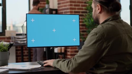 Man Working at Computer with Chroma Key Screen