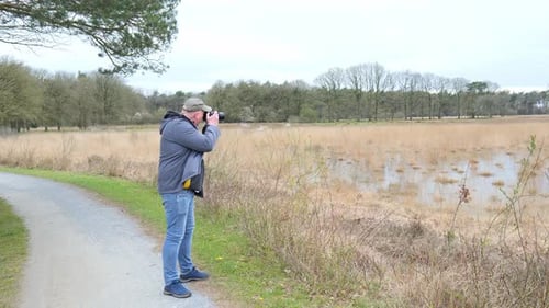 Man Taking Videos Of Nature In The Countryside Using DSLR Camera. - wide