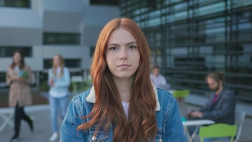Portrait of Attractive Young Redhaired Girl Wearing Backpack Studying at Modern University Campus