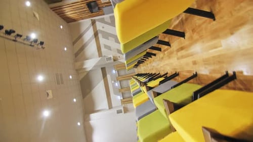 School Auditorium with Colourful Chairs Lit By Spotlights