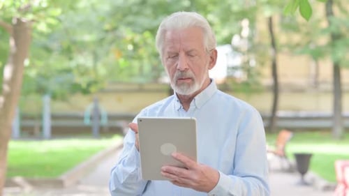 Senior Man Using Tablet for Video Call in Park
