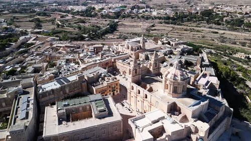 Aerial drone flight over Mdina, Malta, revealing historic medieval architecture and stone citadel,