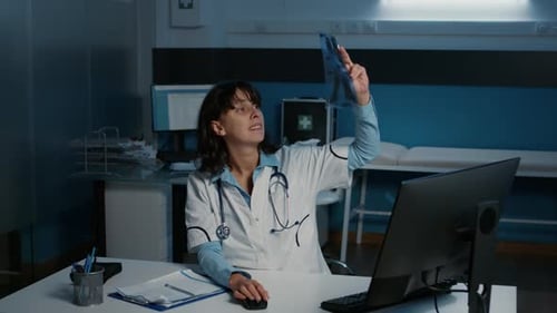 Doctor Examines X-Ray in Dimly Lit Office