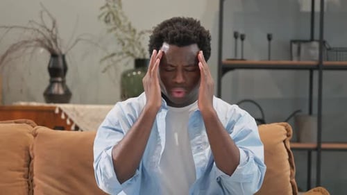 Man Massaging Temples Due To Headache Indoors