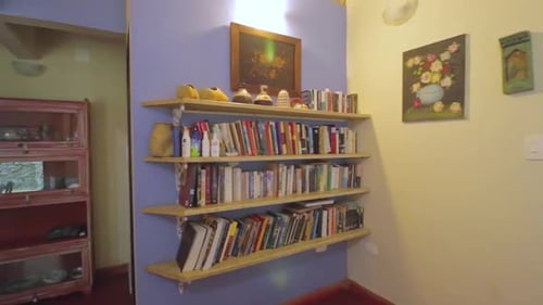 Revealing shot of bookshelve showing very comfortable interior of a house by the sea