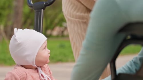 Adorable Baby Eats a Snack Outdoors with Family